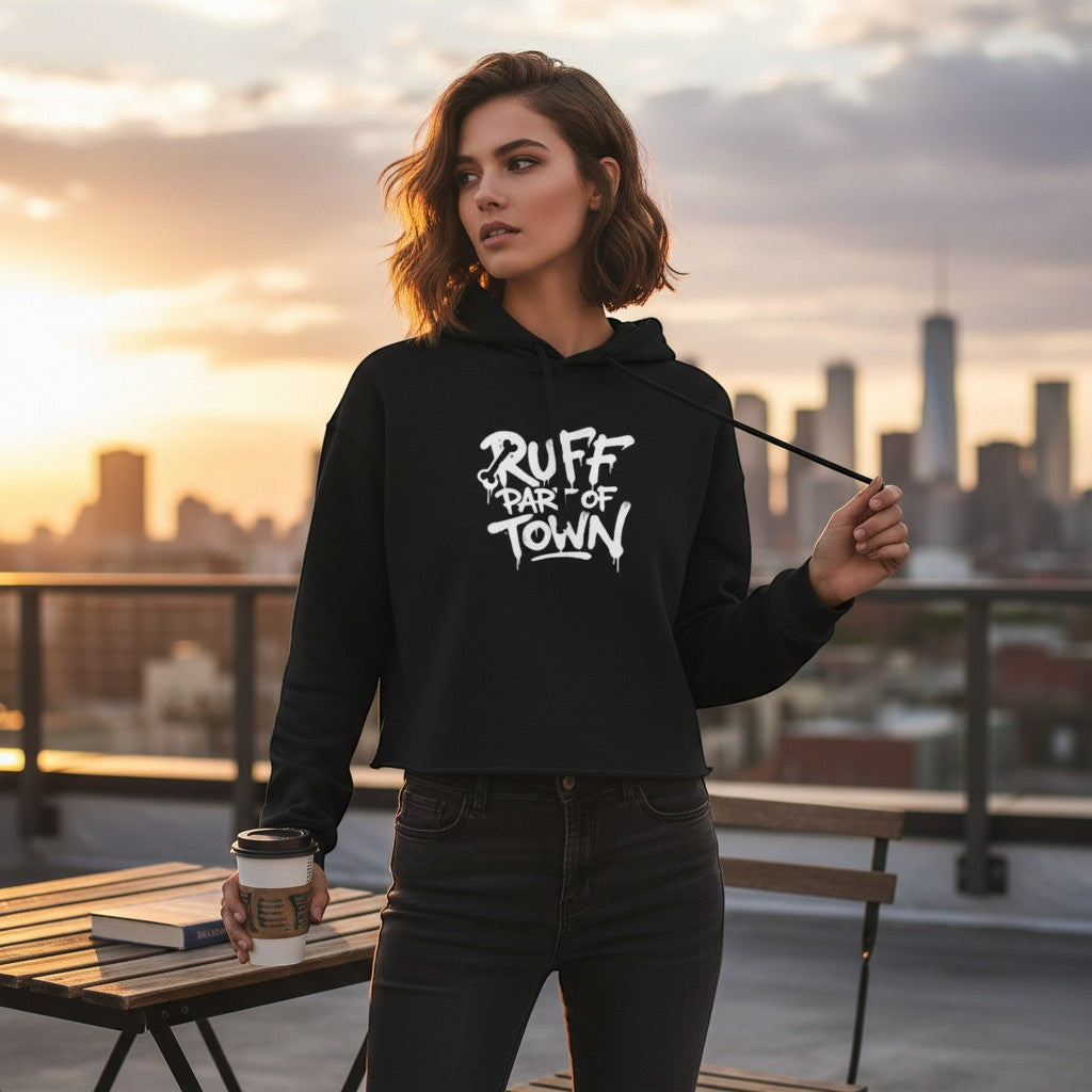 Ruff Part of Town black cropped hoodie with raw hem and white graphic logo, worn by a woman on a rooftop.